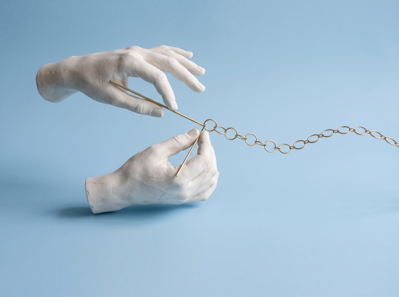 AI integrations connecting your business tools: plaster hands linking brass rings into a chain
