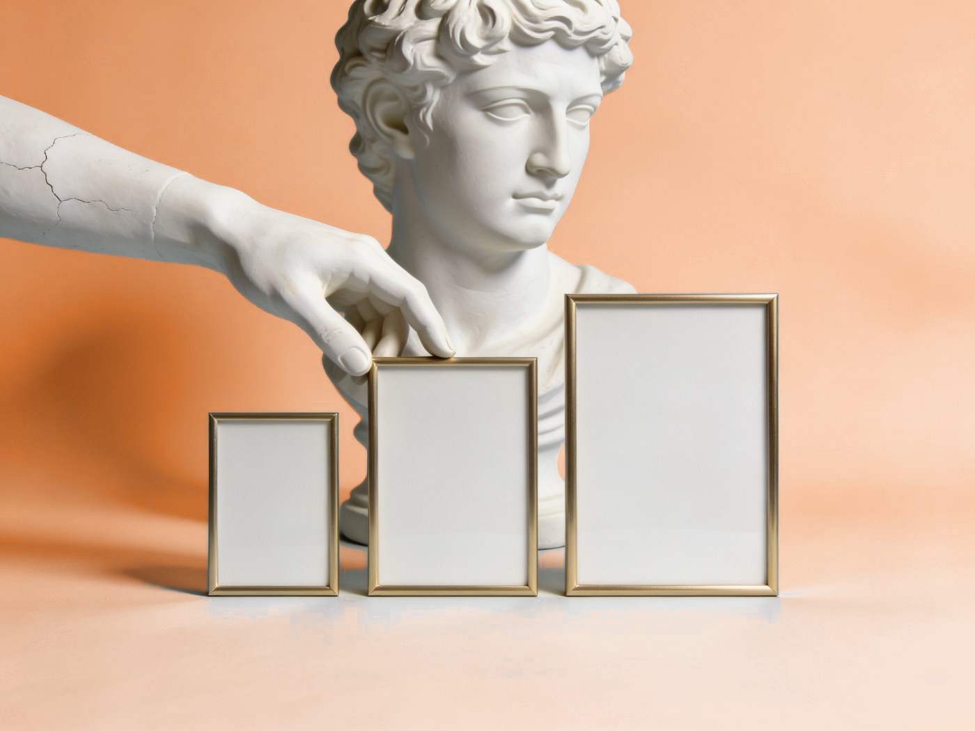 Responsive web development for every screen size: plaster hand arranging three picture frames of different sizes